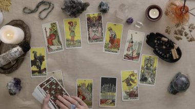 New York, ABD - 1 Mayıs 2021: Parmaklarında iskambil oynayan ve mum ışığında tarot kartları okuyan çingene kadın falcı. Kart kavramında falcılık ve kehanet.