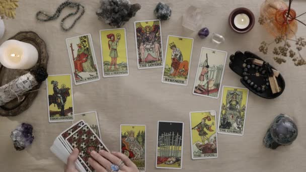 New York, USA - 1 mei 2021: Zigeunerin met tattoos aan haar vingers die solitaire spelen en tarotkaarten lezen bij kaarslicht. Geluk vertellen en waarzeggerij op kaarten concept. — Stockvideo