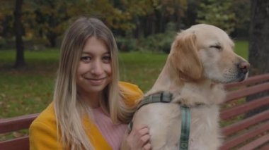 Fransız av köpeğiyle bankta oturan kadının portresi.