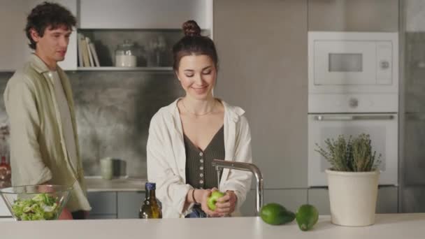 Zamilovaní lidé chatují a usmívají se při vaření v kuchyni — Stock video