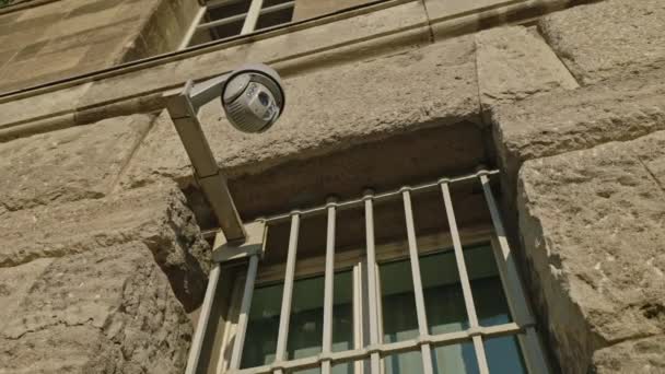 Caméra de sécurité se déplaçant panoramique et enregistrement inclinable ce qui se passe à l'extérieur d'un bâtiment. Concept de vidéosurveillance motorisée. — Video