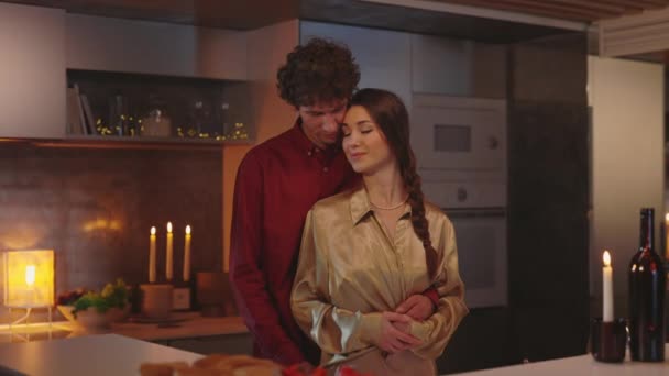 Porträt zweier verliebter Menschen, die sich in der Küche umarmen — Stockvideo