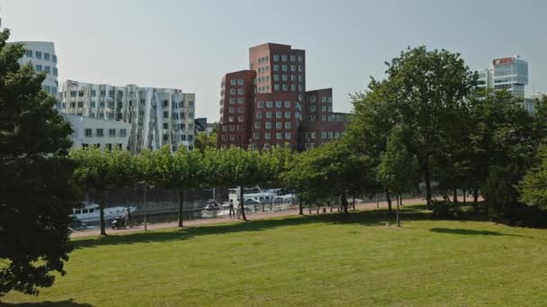 DUSSELDORF, ALLEMAGNE - 1er juillet 2021 : Vue en angle élevé depuis le drone du bâtiment moderne de Düsseldorf, Allemagne. Complexe de bâtiments de luxe debout sur la rue près d'un magnifique parc le jour ensoleillé. — Video