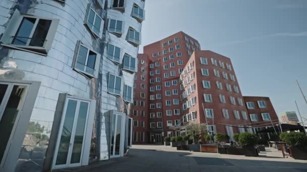 DUSSELDORF, NIEMCY - 1 lipca 2021: Niski kąt widzenia na nowoczesne budynki w kompleksie Neue Zollhof w Dusseldorfie, Niemcy. Widok przycięty. Zastrzelony w słoneczny letni dzień. — Wideo stockowe