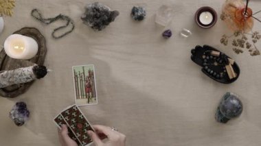 New York, ABD - 1 Mayıs 2021: Masadaki tarot kartının üst görüntüsü. Falcı kadın masaya koyarken tarot kartlarıyla geleceği okuyor. Esrarengiz kavram, falcılık ve tahminler.