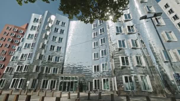 DUSSELDORF, ALEMANIA - 1 de julio de 2021: Edificio de metal brillante famoso de Neuer Zollhof en Media Harbor Medienhafen, diseñado por Frank O. Gehry, terminado en 1998. Espectacular arquitectura posmoderna. — Vídeo de stock