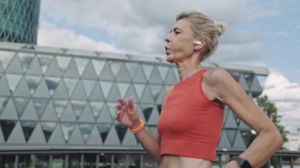 Femme en vêtements de sport prenant une pause pendant la course dans la rue de la ville — Video