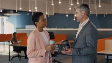 Ofis hayatı, genç bir kadın yakışıklı bir erkek arkadaşla konuşuyor ve gülüyor. Gülümseyen erkek ve kadın ofis çalışanları koridorda durup iş arasında bir şey tartışıyorlar..