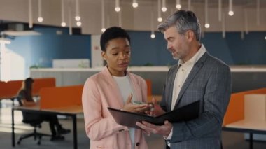 İş merkezinde yan yana duran ve ortak projeyi tartışan iki menejer. İş arkadaşları kahve içiyor, elinde belgelerle klasör tutuyor ve dijital tablet kullanıyor. Uyumlu çeşitlilik kavramı.