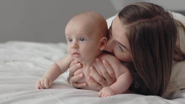 Мать обнимает и целует новорожденного сына — стоковое видео