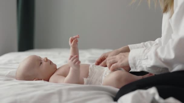 Прихильна мати змінює памперс на новонароджену дитину — стокове відео