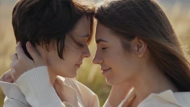 Dos mujeres cariñosas abrazándose soñadoramente al aire libre — Vídeos de Stock