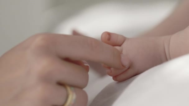 Közelkép az anyákról kéz megérintette az újszülött lábát. — Stock videók