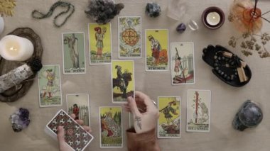 New York, ABD - 1 Mayıs 2021: Falcının masa tarot kartlarını masaya koyup okumaya hazırlandığı esrarengiz bir kare. Eldiven okuyucu iş yerinde oturuyor. Esrarengiz ve kart okuma kavramı.
