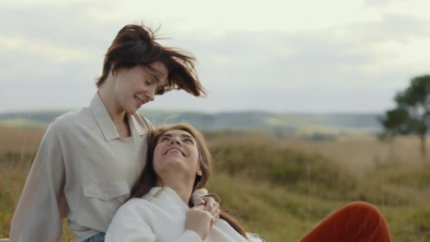 Feliz pareja lesbiana hablando y sonriendo entre la naturaleza — Vídeos de Stock