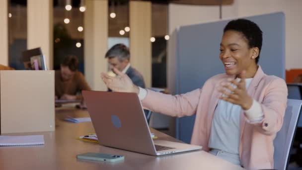 Feliz mujer de negocios afroamericana regocijando grandes noticias en la oficina moderna. Gerente mujer trabajando en el portátil. Proyecto de finalización exitoso, celebrando acuerdo. — Vídeos de Stock