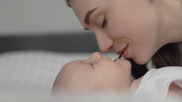 Close-up van zorgzame moeder zoenen en knuffelen haar baby — Stockvideo