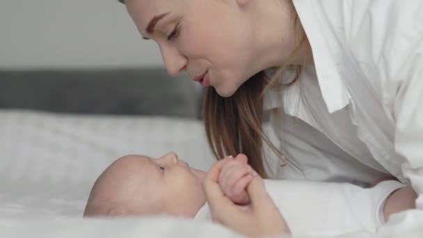 Affectionate mother holding hands with her toddler son — Stock Video