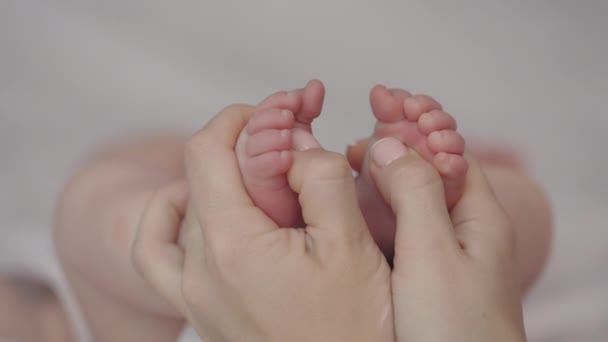 Close-up van vrouwelijke handen masseren voet van haar pasgeboren baby — Stockvideo