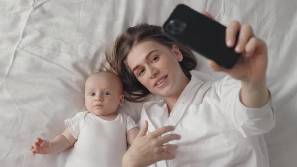 Мать с сыном используют мобильный телефон для видеозвонков — стоковое видео