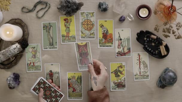 New York, USA - 1 mei 2021: Vrouwelijke tarotlezer die kaarten deelt en toekomst en fortuin leest. Een vrouw die kaarten aan tafel legt. Occult, esoterisch, waarzeggerij en hekserij concept. — Stockvideo