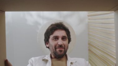 Hüsrana uğramış sakallı adam paketi boşaltıyor.