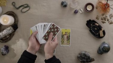 New York, ABD - 1 Mayıs 2021 Kadın müşteri falcı ellerinde bir kart alarak onun için tahminlerde bulunurken mistik ayin olarak kartları sıraladı. Okültizm ve astroloji kavramı.