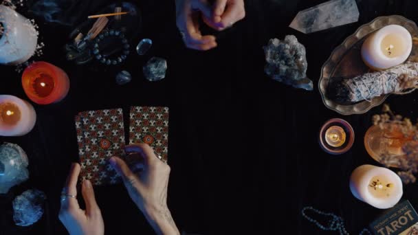 Nueva York, EE.UU. - 1 de mayo de 2021: Mujer colocando cartas del tarot durante el ritual esotérico. El adivino pronostica el destino colocando cartas con vela sobre la mesa. Cliente apuntando con el dedo a la tarjeta. — Vídeo de stock