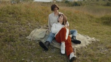 Mutlu lezbiyenler, temiz havada sarılıp dinleniyorlar.