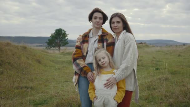 Blank lgbt familie van drie poseren in omhelzing buiten — Stockvideo