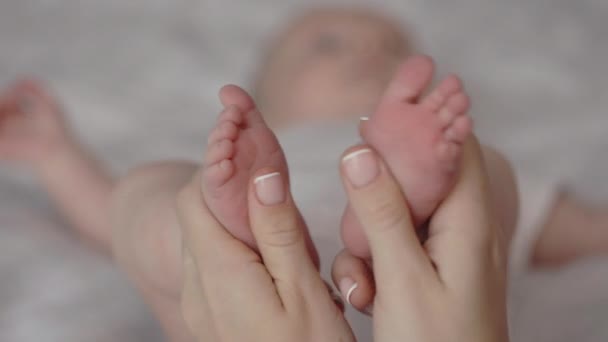 Close up of mother touching gently bare feet of newborn son — Stock Video