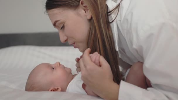 Lycklig mor leker och pratar med sin nyfödde son — Stockvideo