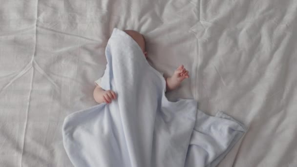 Feliz bebé recién nacido escondido bajo una manta suave — Vídeos de Stock
