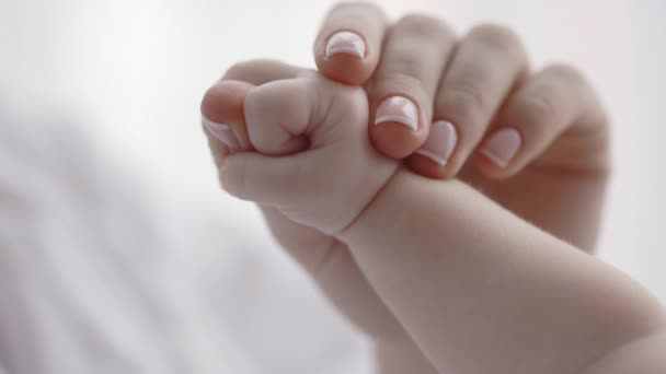 Маленька новонароджена дитина тримає палець своєї дбайливої матері — стокове відео