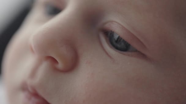 Primo piano del bambino con gli occhi azzurri sdraiato sulle mani delle madri — Video Stock