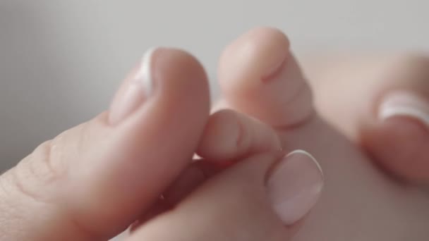 Крупним планом маленька гола нога немовляти в руках матерів — стокове відео