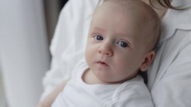 Yeni doğmuş şirin çocuk annesinin ellerinde oturuyor.