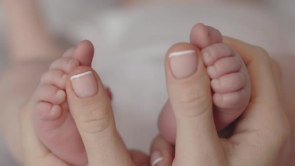 Крупним планом жінка м'яко масажуючи ноги для її маленької дитини — стокове відео