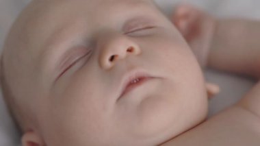 Yatakta çıplak uyuyan sevimli bebeğe yakın dur.