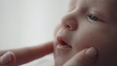 Sevecen anne yeni doğan oğlunun yanaklarına dokunuyor.