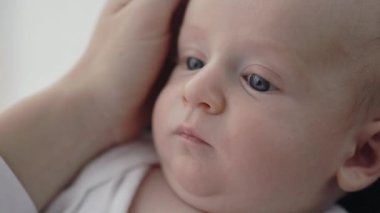 Sevimli yeni doğmuş çocuk annesine bakıyor.