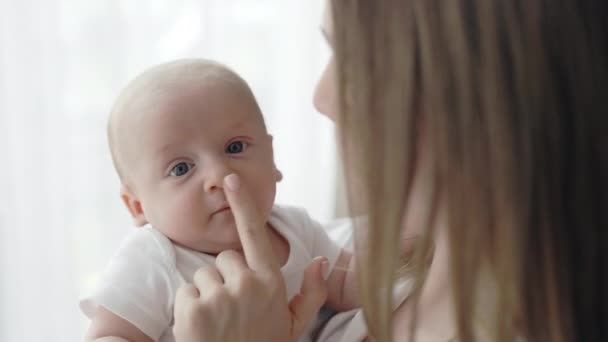 Ung kvinna smeker försiktigt näsan av sin nyfödde son — Stockvideo