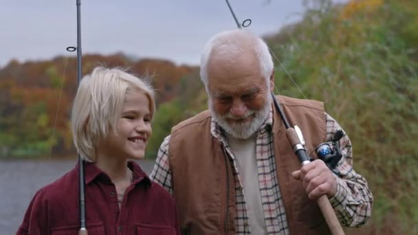 Opa met kleinzoon genieten van hengelen tijd samen op meer — Stockvideo