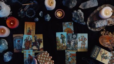 New York, ABD - 1 Mayıs 2021: Tarot okuyucu geleceği ve serveti. Kadın ellerinin yukarıdaki görüntüsü, karanlık odada tahmin yaparken masa resmine kartlar koyuyor. Kahin kavramı.