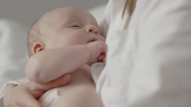 Mother holding on hands adorable sleepy baby boy — стоковое видео