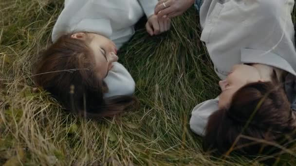 Mesmo sexo casal de mãos dadas enquanto deitado na grama — Vídeo de Stock