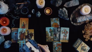 New York, ABD - 1 Mayıs 2021: Tarot kartı masada. Falcı kadın, karanlık odanın içindeki masaya koyarken tarot kartlarıyla geleceği okuyor. Esrarengiz kavram, falcılık.
