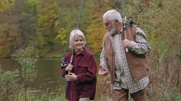 Nieto pasar tiempo con el abuelo para la pesca en el lago — Vídeo de stock