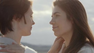 Kapalı gözlü iki büyüleyici lezbiyen dışarıda dikiliyor.