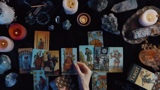 New York, USA - 1 May 2021: Fortune teller putting on the table tarot cards and preparing to reading it while sitting at the dark interior. Esoteric and cards reading concept. — Vídeos de Stock